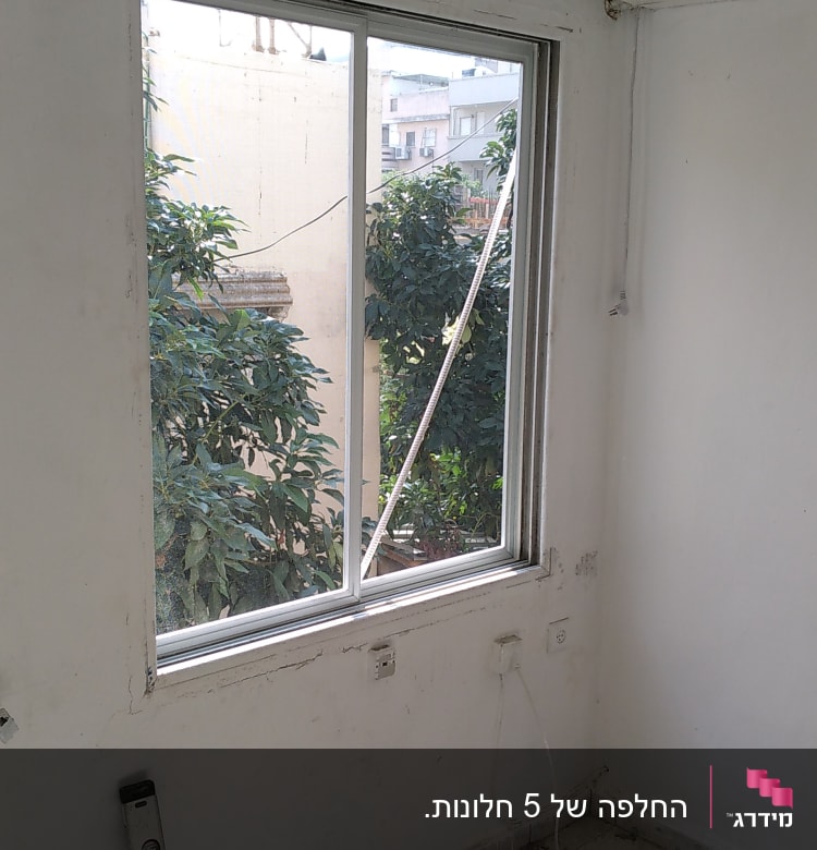 חלון אלומיניום עם מסגרת לבנה בחדר